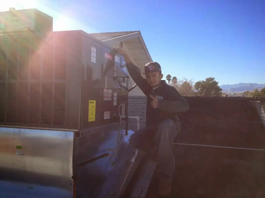 HVAC technician performing AC Tune-Up on a rooftop unit in Westfield