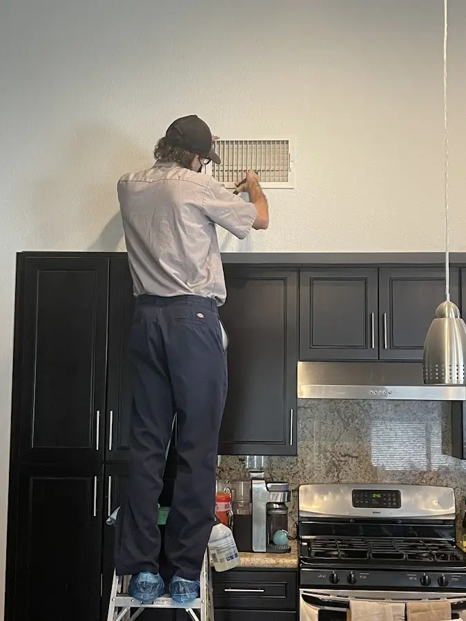 Technician inspecting an air vent during HVAC service in Westfield